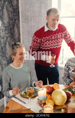 Handsome old pensive man with a glass standing near the table eating chips. close up photo.celebration. Stock Photo