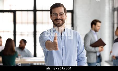 Head shot portrait smiling businessman extending hand for handshake Stock Photo