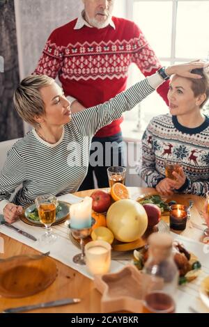 young smiling woman petting her sister during the dinner, good relation. close up cropped portrait Stock Photo