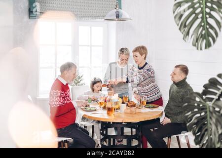 young women putting meat on the guests' plates. appetizing turkey for the whole family Stock Photo