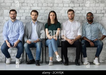 Portrait confident diverse candidates sitting in row, waiting for interview Stock Photo