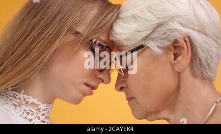Extreme close up shot of young and senior woman touching foreheads. High quality photo Stock Photo