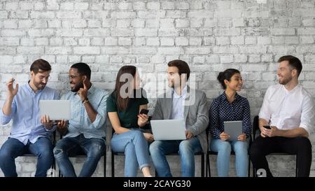 Friendly diverse candidates talking while waiting for job interview Stock Photo