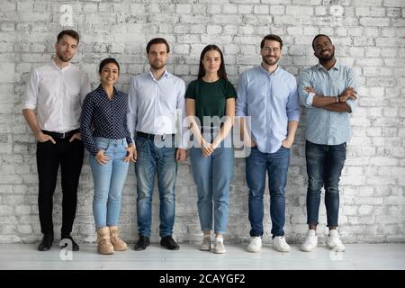 Full length portrait motivated successful diverse employees team standing together Stock Photo