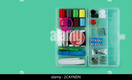A banner with a sewing kit: scissors, tape measure, thimbles, threads and buttons. Sewing creativity concept. Stock Photo