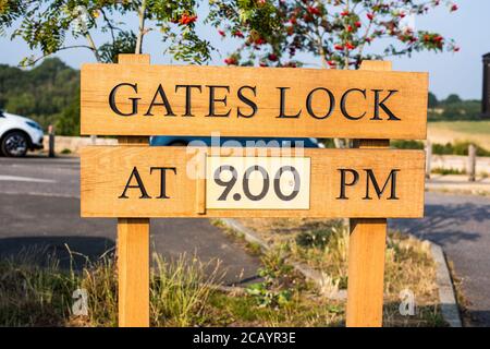 Gates lock at 9 PM sign board in open space car park Stock Photo