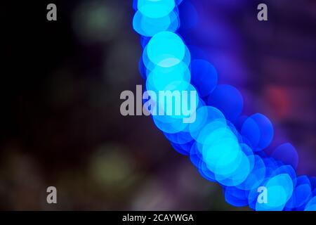 Arc of glowing blue bokeh lights on a dark background, abstract backdrop Stock Photo