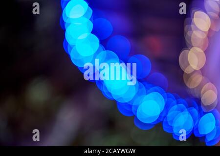 Curve of large blue bokeh circles and soft orange lights, abstract night background Stock Photo