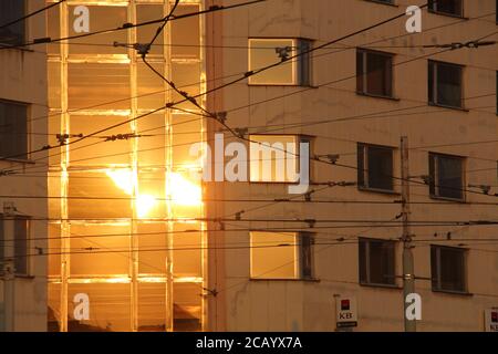 In Palmovka, Prague, Czech Republic, you can see the setting sun's light of yellow/ orange colours being reflected on the building for that bank, KB. Stock Photo