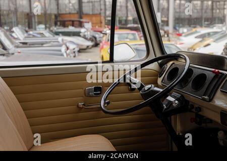 Black steering wheel wing and interior view of vintage and classic VW, Volkswagen Bus or Van at at Classic Remise in Düsseldorf, Germany. Stock Photo