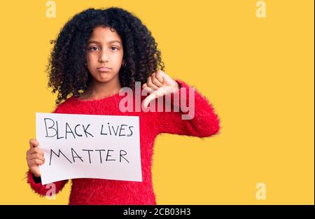 African american child with curly hair holding black lives matter banner with angry face, negative sign showing dislike with thumbs down, rejection co Stock Photo