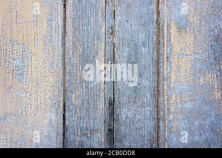 Yellow peeling paint texture and faded wood background on an old wooden door. Stock Photo