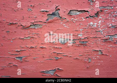 Abstract red texture background with peeling paint close up and mottled patterns. Stock Photo
