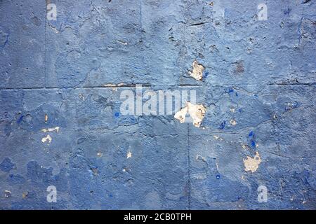 Abstract blue background texture with flecks of concrete wall damage and white plaster. Stock Photo