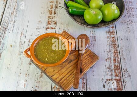 Mexican green sauce with tortilla chips, tomatillos and serrano pepper Stock Photo