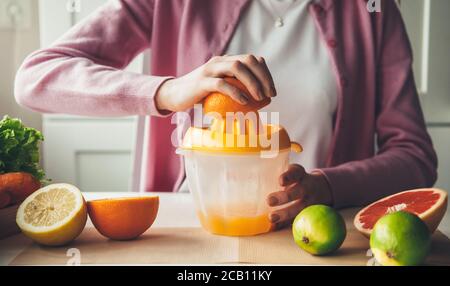Manual squeezing procedure and making fruit juice at home out of orange Stock Photo