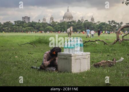 Kolkata, India. 09th Aug, 2020. A little girl sells mineral water in the largest urban park of Kolkata named Maidan (also known as the Brigade Parade Ground) on a cloudy afternoon amidst covid-19 pandemic. (Photo by Jit Chattopadhyay/Pacific Press) Credit: Pacific Press Media Production Corp./Alamy Live News Stock Photo