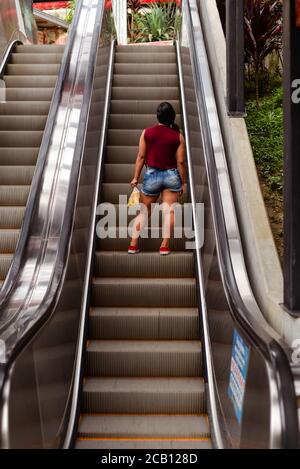 Medellin / Colombia - July 15, 2017: unrecognizable colombian woman going up escalator in Comuna 13 Stock Photo