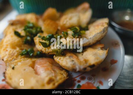 Vietnamese street food 'banh can' make by rice powder with rice flour, egg, onion leaves. Banh can is a portion of Vietnamese street food. Food photog Stock Photo