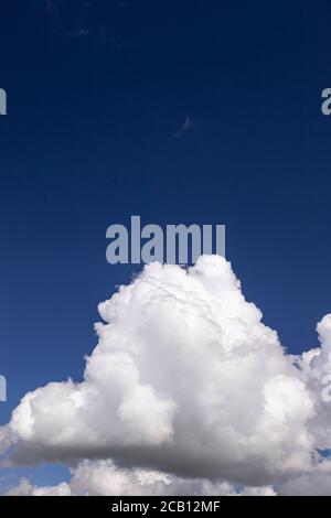 Large cumulus cloud in a deep blue sky Stock Photo