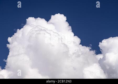 Large cumulus cloud in a deep blue sky Stock Photo