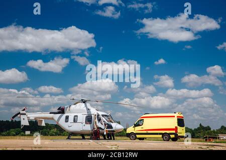 A helicopter and an ambulance are on the runway. Transport concept for medical personnel. Stock Photo