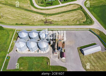 modern industrial silos for long term storage of grains on the farm. aerial photo from the drone Stock Photo