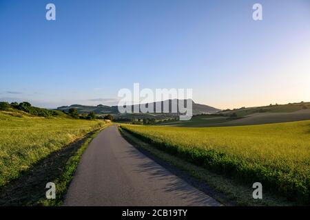 Country road leads through the volcanic landscape of Hegau, right of the Hohenstoffeln, Baden-Wuerttemberg, Germany Stock Photo