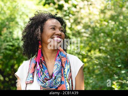 Portrait of a laughing, dark-skinned woman with curly hair and colourful scarf, Germany Stock Photo