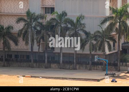Mumbai, Maharashtra, India - March 2020: Palm trees fringing a basketball court in a college ground in suburban Mumbai. Stock Photo