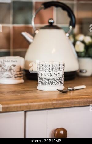 Vertical selective focus shot of a teacup with Thank You text on the kettle background Stock Photo