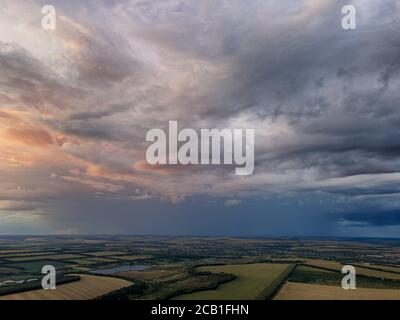 Rain clouds over green fields and lakes. Aerial photo. Stock Photo