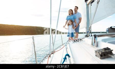 Family Embracing Standing On Yacht Relaxing On Weekend Outdoors, Panorama Stock Photo