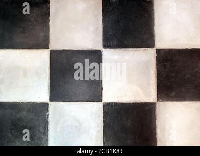 Old porcelain checkered tiles floor texture with tiles of white and black colors Stock Photo