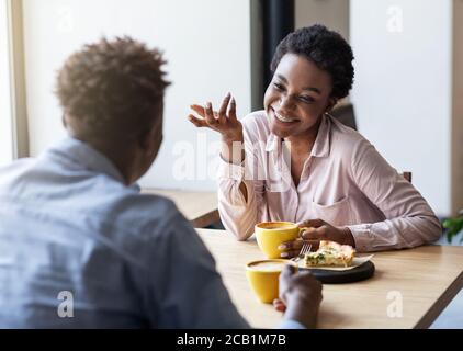 Loving African American couple chatting in coffee shop at lunchtime Stock Photo