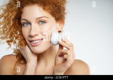 Beautiful young woman using facial cleaning massage brush Stock Photo