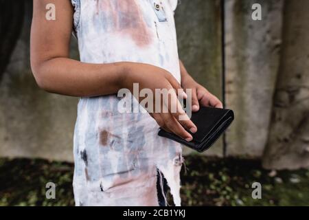 Cropped view of poor african american kid holding wallet on urban street Stock Photo