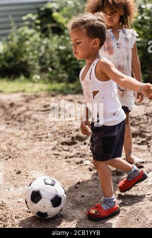 Selective focus of destitute african american children playing football ...