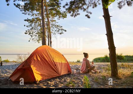 Charming female traveler drinking coffee on the beach Stock Photo