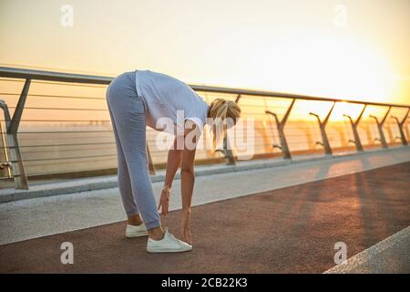 Flexible female performing a leg stretching exercise Stock Photo