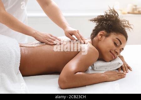 Black ypung woman getting exfoliating beauty procedure Stock Photo