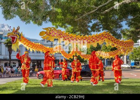 A group of colorfully dressed Chinese dragon dancers in a park during the Chinese New Year celebrations. Hamilton, New Zealand, 2/16/2019 Stock Photo