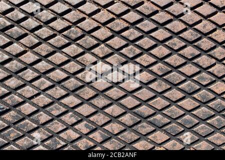 rusty retro wide angle view diamond plate storm drain cover suitable for website marketing background backdrop setting architecture architectural layo Stock Photo