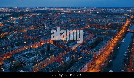 Aerial panoramic view of Amsterdam city in evening. Famous Dutch channels and dancing houses from above. Netherlands, Europe. Stock Photo