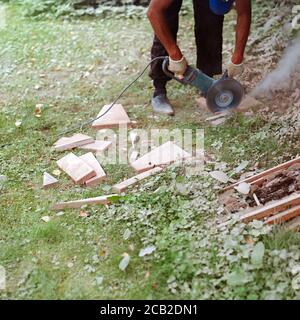 Cutting tiles outdoor with a hand tile cutter, shallow depth of filed Stock Photo