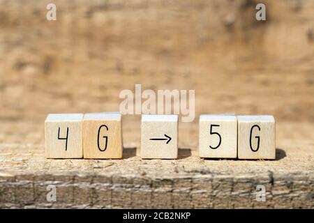 Wooden cubes From 4g To 5g with black arrow pointing On wooden background, mobile or technology concept Stock Photo