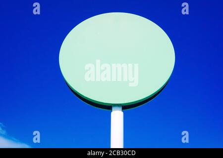 A blank circular  sign  to include text, with blue sky background and copy space. Stock Photo