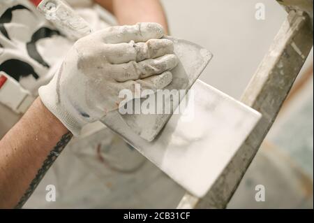 Construction mason worker with spatula and mortar. Construction tools Stock Photo