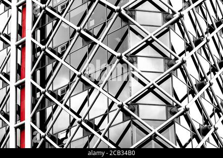 Architectural abstract. Generic modern building exterior in black and white with a touch of red. Horizontal tubular framework over glass. Stock Photo