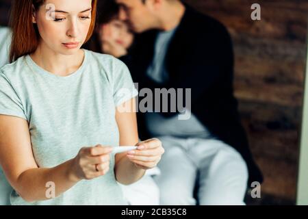family concept. caucasian woman check temperature of sweet daughter suffering from cold at home, lying on bed with careful mother and father Stock Photo